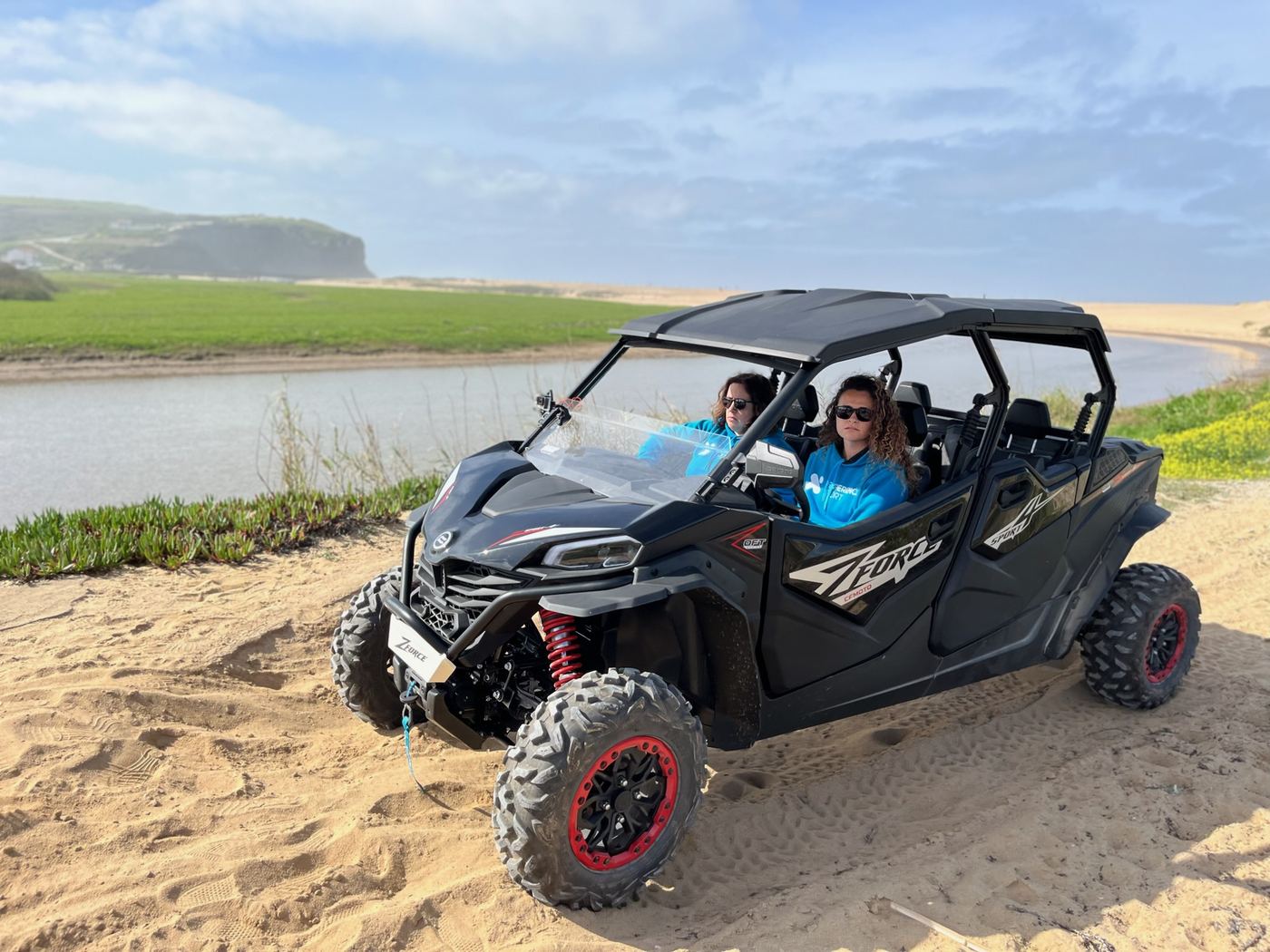 Kart cross na areia junto à foz de um rio, com arribas ao fundo